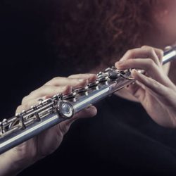 Close-up of a woman playing the flute. Musical concept Close-up of a woman playing the flute. Musical concept